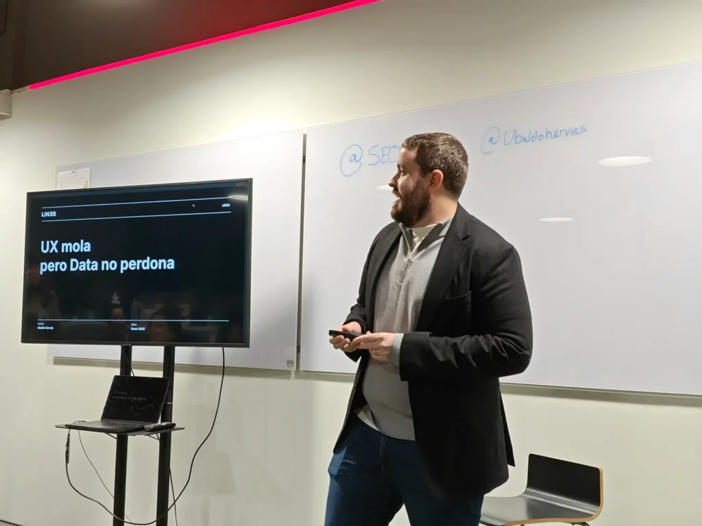 Ubaldo Hervás dando una ponencia sobre CRO en el evento de DobleSEO, con una diapositiva de fondo que dice 'UX mola pero Data no perdona